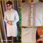 Man wearing a jacquard Pakistani Panjabi with textured fabric, styled collar, and buttoned placket, standing in a studio setting.