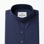 Top view of folded Togor & Tweed Navy Pakistani Jacquard Panjabi highlighting the textured fabric, tonal embroidered collar, and metallic buttons on a white background