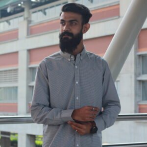 Man wearing a white premium textured striped shirt with sunglasses, standing outdoors near greenery and a sidewalk, styled for a modern yet traditional look.