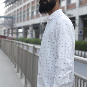 Man wearing a white premium textured striped shirt with sunglasses, standing outdoors near greenery and a sidewalk, styled for a modern yet traditional look.