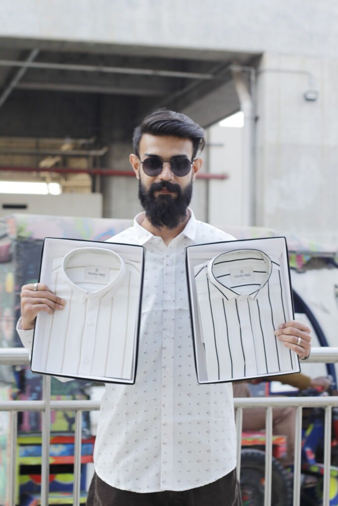 Man wearing a white premium textured striped shirt with sunglasses, standing outdoors near greenery and a sidewalk, styled for a modern yet traditional look.