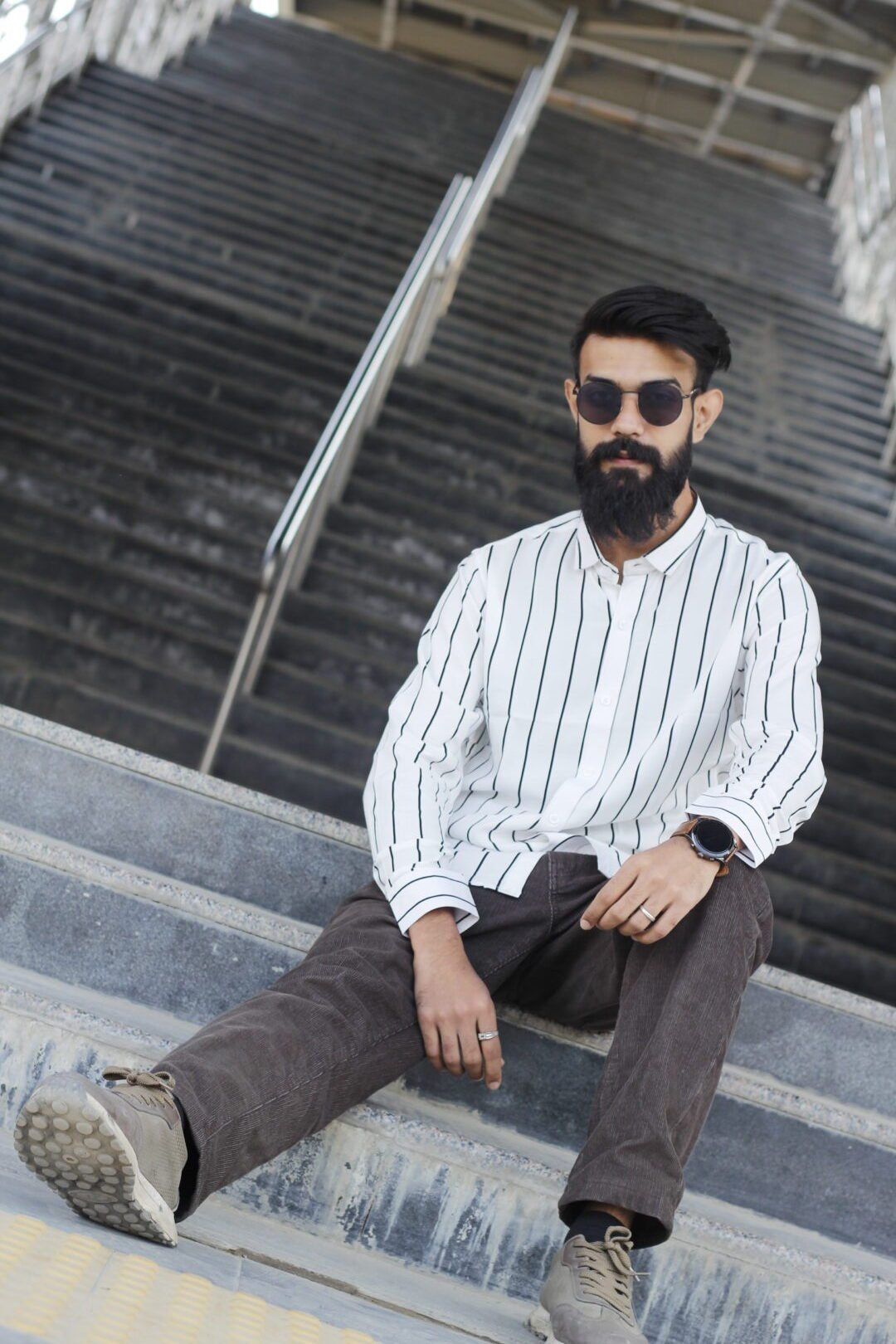 Premium White Textured Striped Shirt – Timeless Elegance Man wearing a white premium textured striped shirt with sunglasses, standing outdoors near greenery and a sidewalk, styled for a modern yet traditional look.