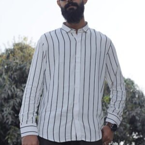 Man wearing a white premium textured striped shirt with sunglasses, standing outdoors near greenery and a sidewalk, styled for a modern yet traditional look.